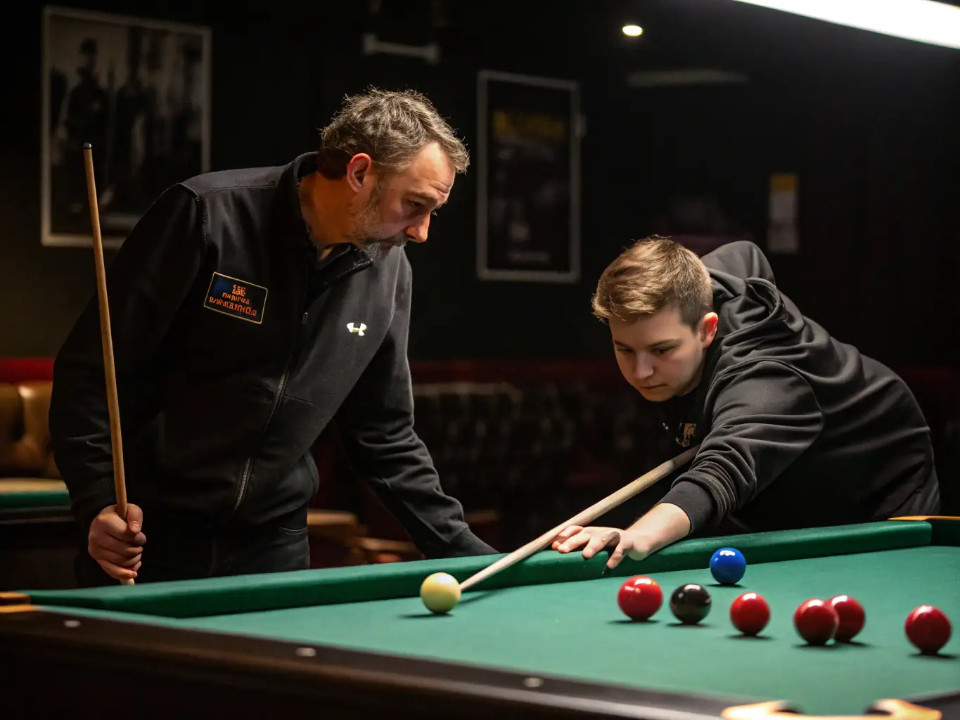 An image of players practicing billiards in a well-lit, professional club environment, showcasing focused individuals and coaching sessions.